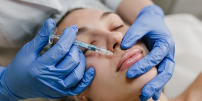 closeup-portrait-young-woman-doing-botox-procedures-by-professional-injection-making-lips-modern-devices-technology-medicine-cosmetology-therapy-min